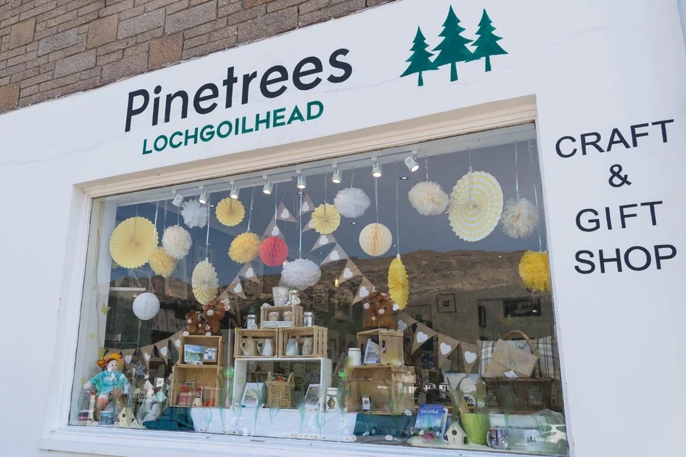 Shop window with crafts, gifts, and paper decorations.
